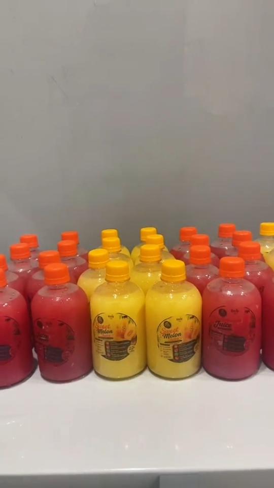 Rows of freshly bottled Uzzy Sweet Melon and watermelon juice on the production counter